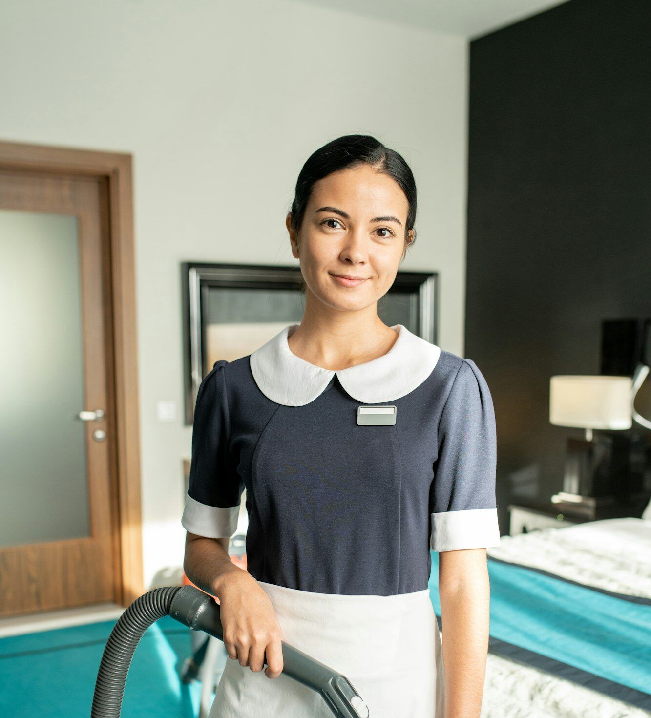 Beautiful chambermaid with vacuum cleaner